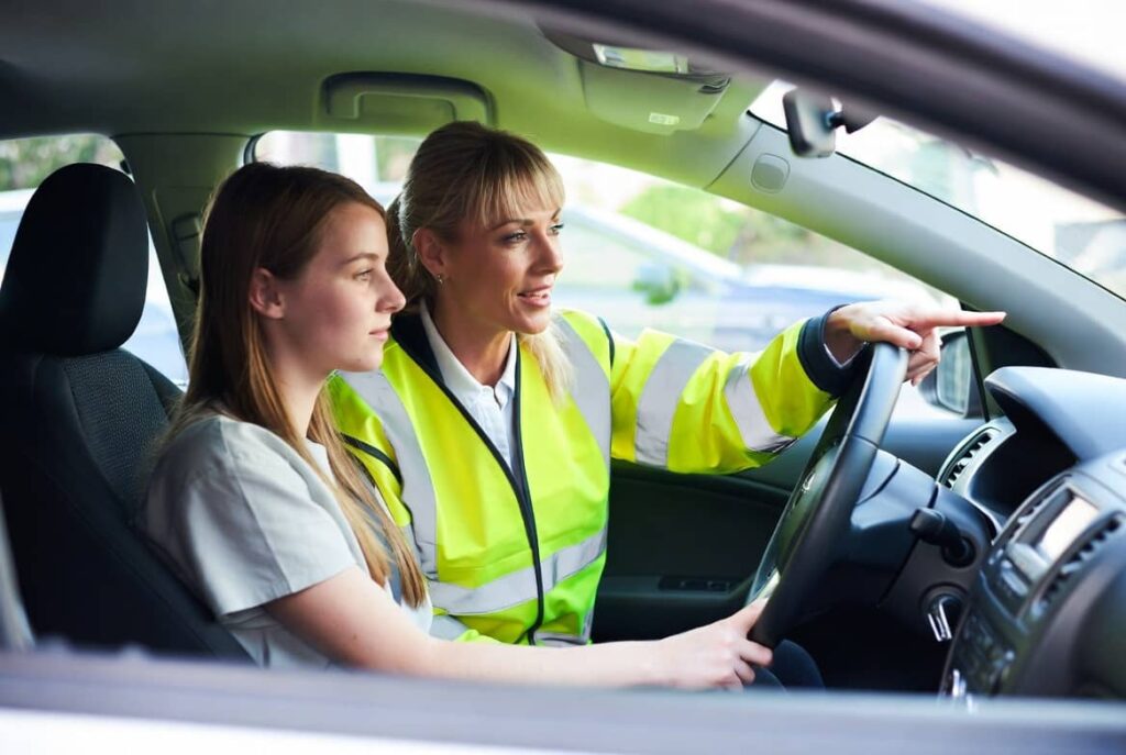 "Female driving instructor explaining car controls to a new learner